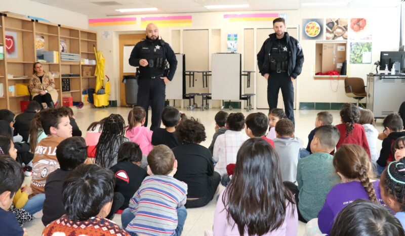 Officers from the Aurora Police Department speak to 2nd grade students.